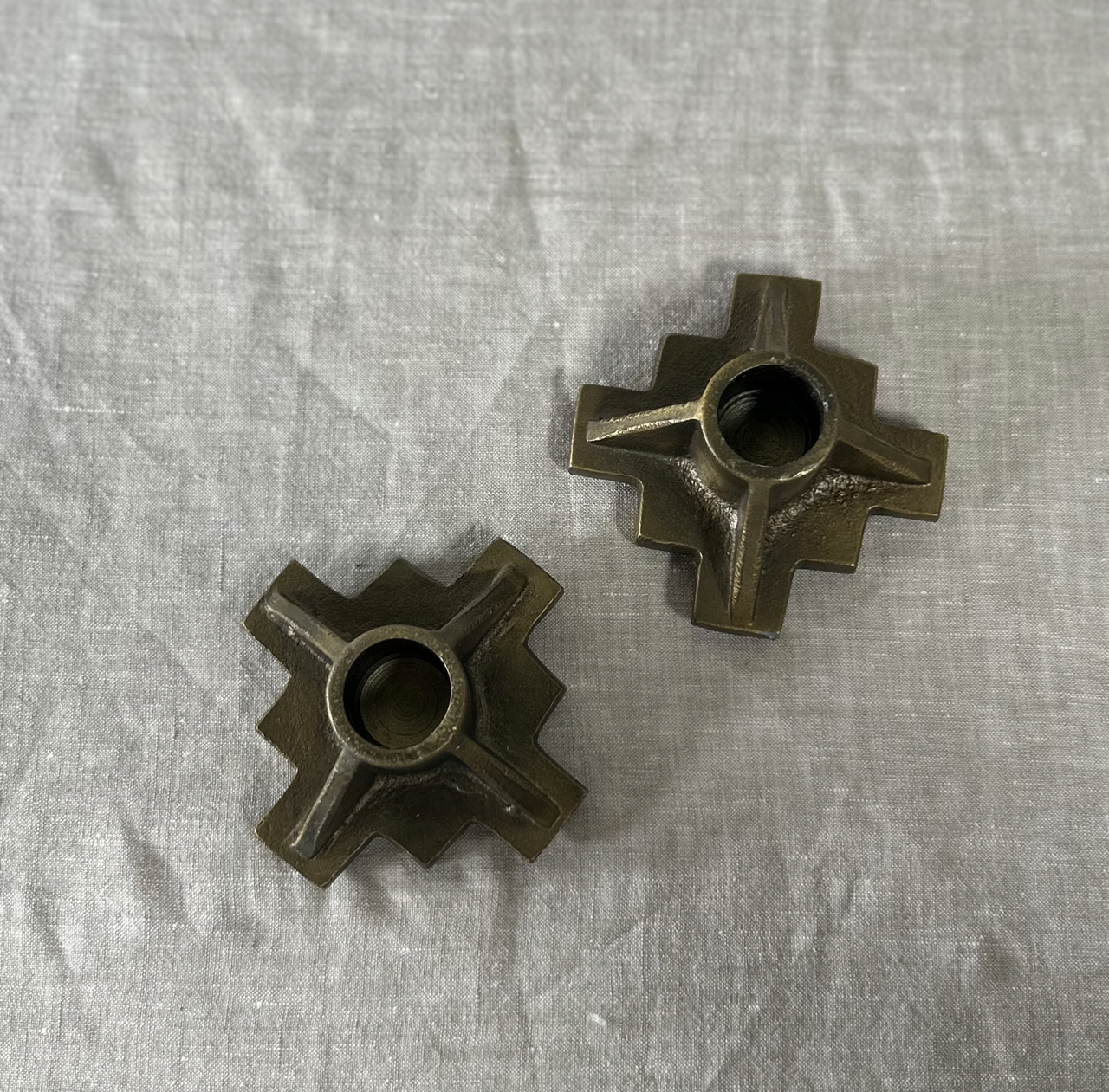 Two metallic star-shaped objects on a textured gray surface