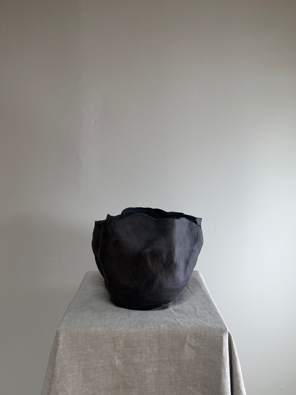 Black bag on a gray tablecloth with a plain white background