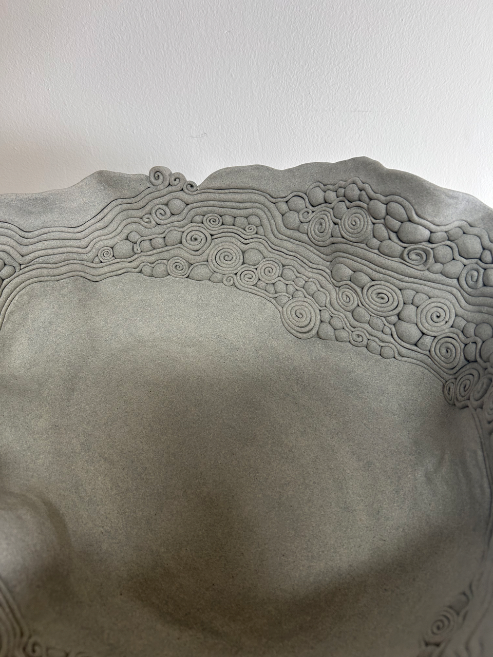 Close-up of a textured ceramic bowl with intricate patterns on a white background