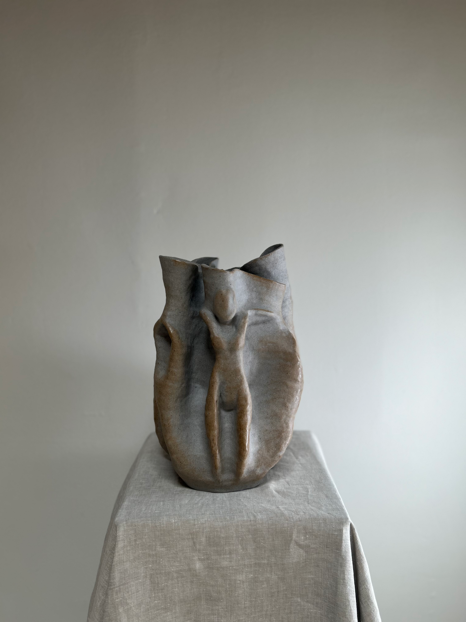 Ceramic vase on a pedestal against a plain background