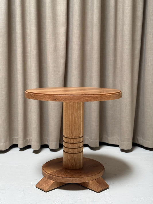 Wooden side table against a beige curtain background