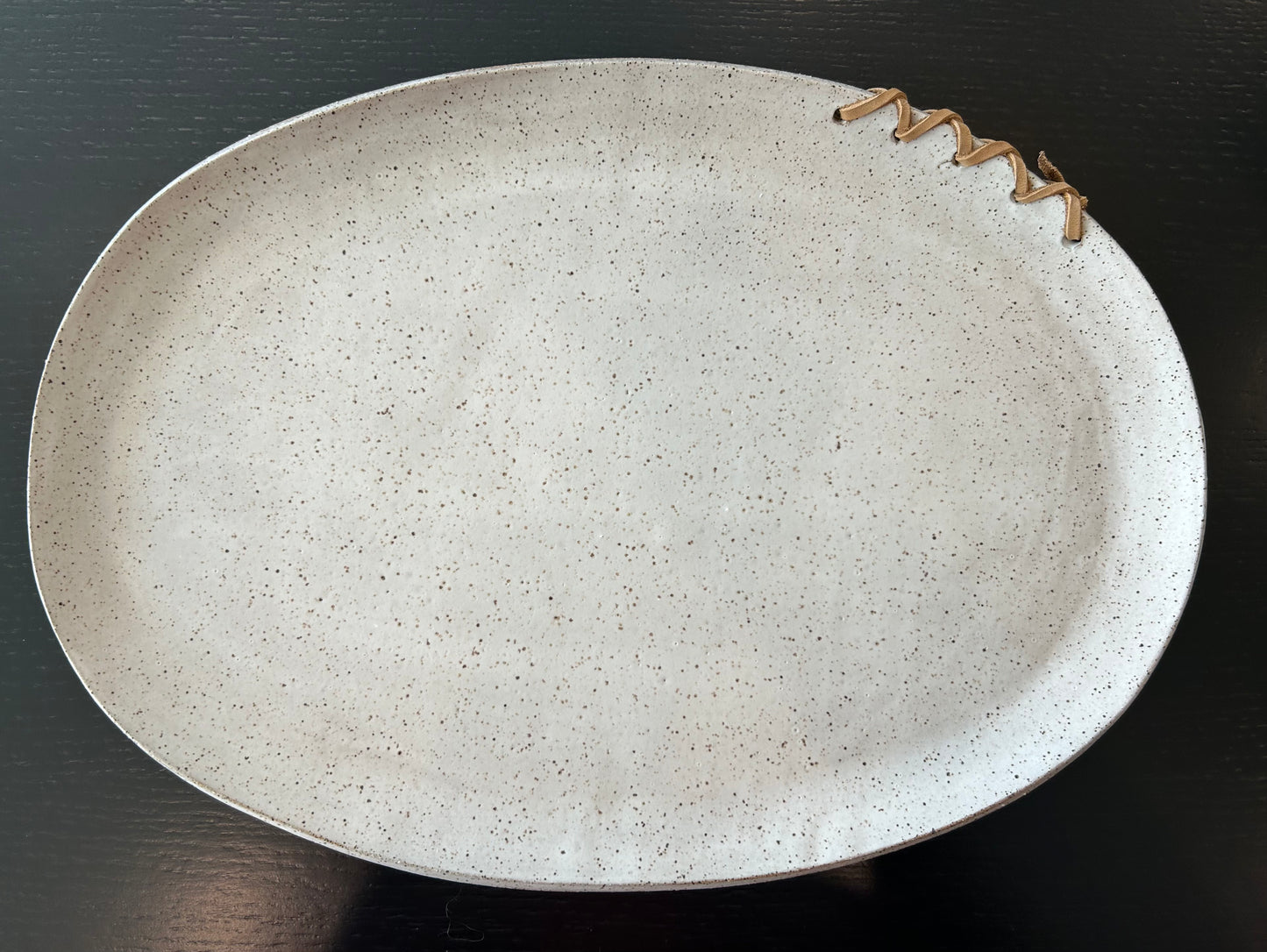 handmade ceramic platter, NSV Ceramics, speckled stoneware tray, leather stitched plate, artisan serving dish, minimal tabletop, neutral ceramic decor, matte glaze pottery, functional ceramic art, handcrafted dining ware