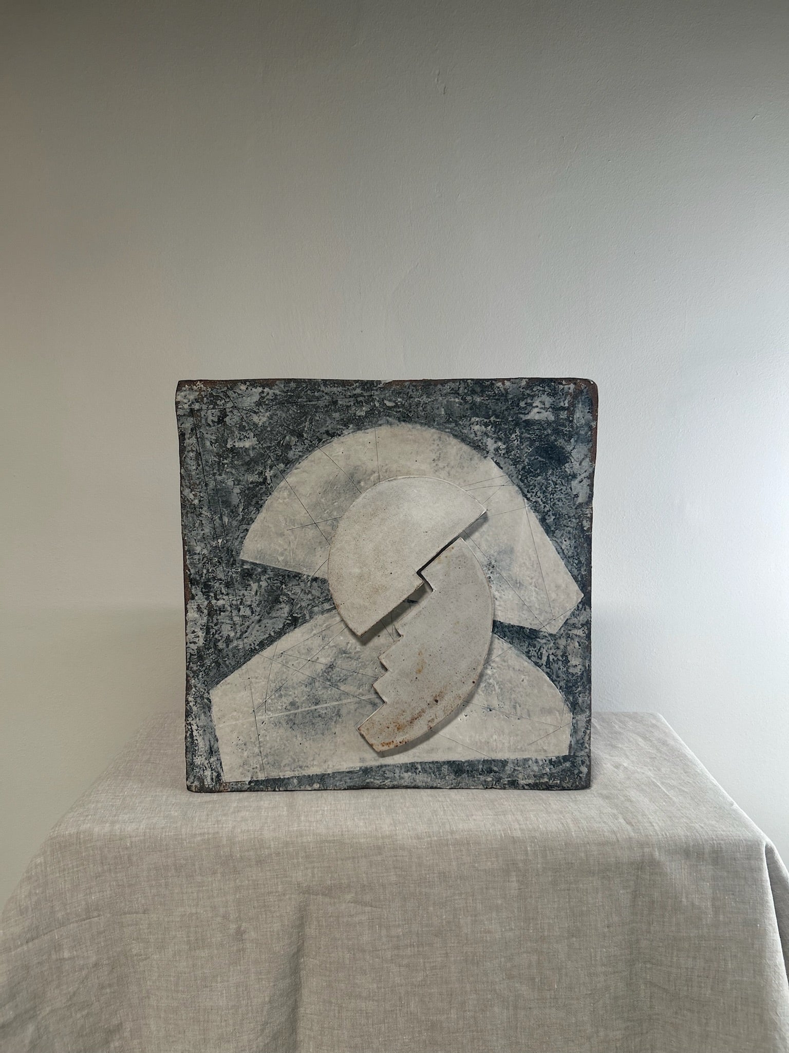 Abstract sculpture on a white surface with a neutral background