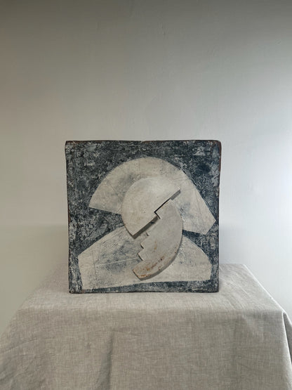 Abstract sculpture on a white surface with a neutral background