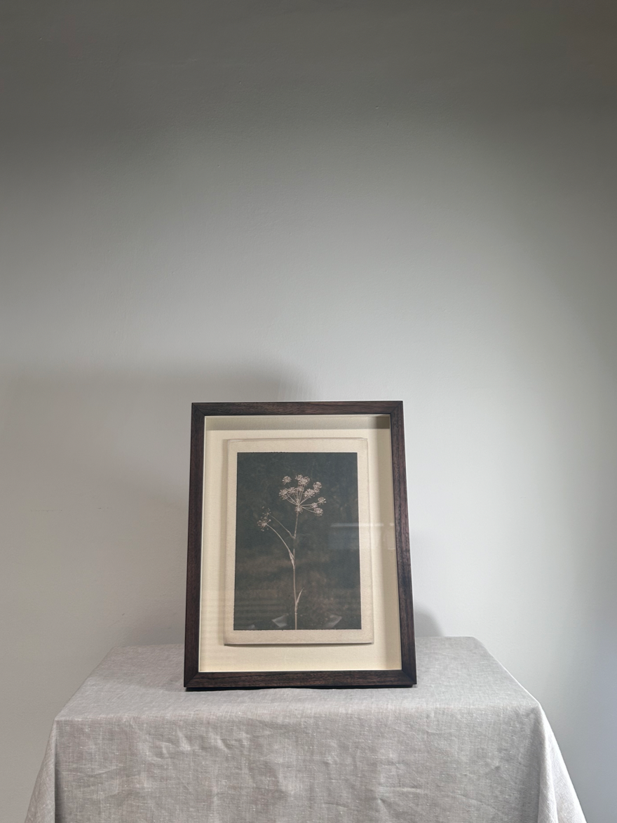 Framed artwork on a table with a plain background