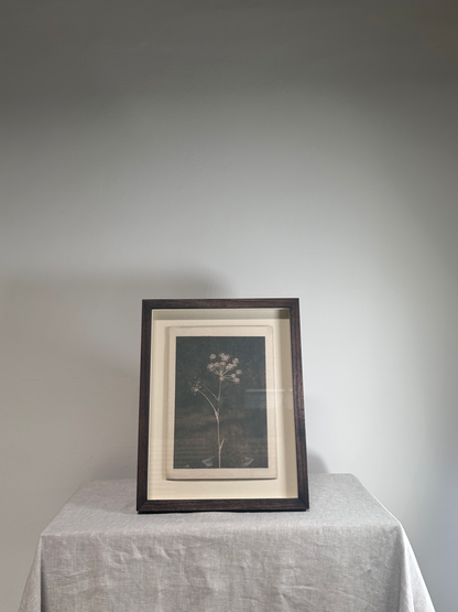 Framed artwork on a table with a plain background