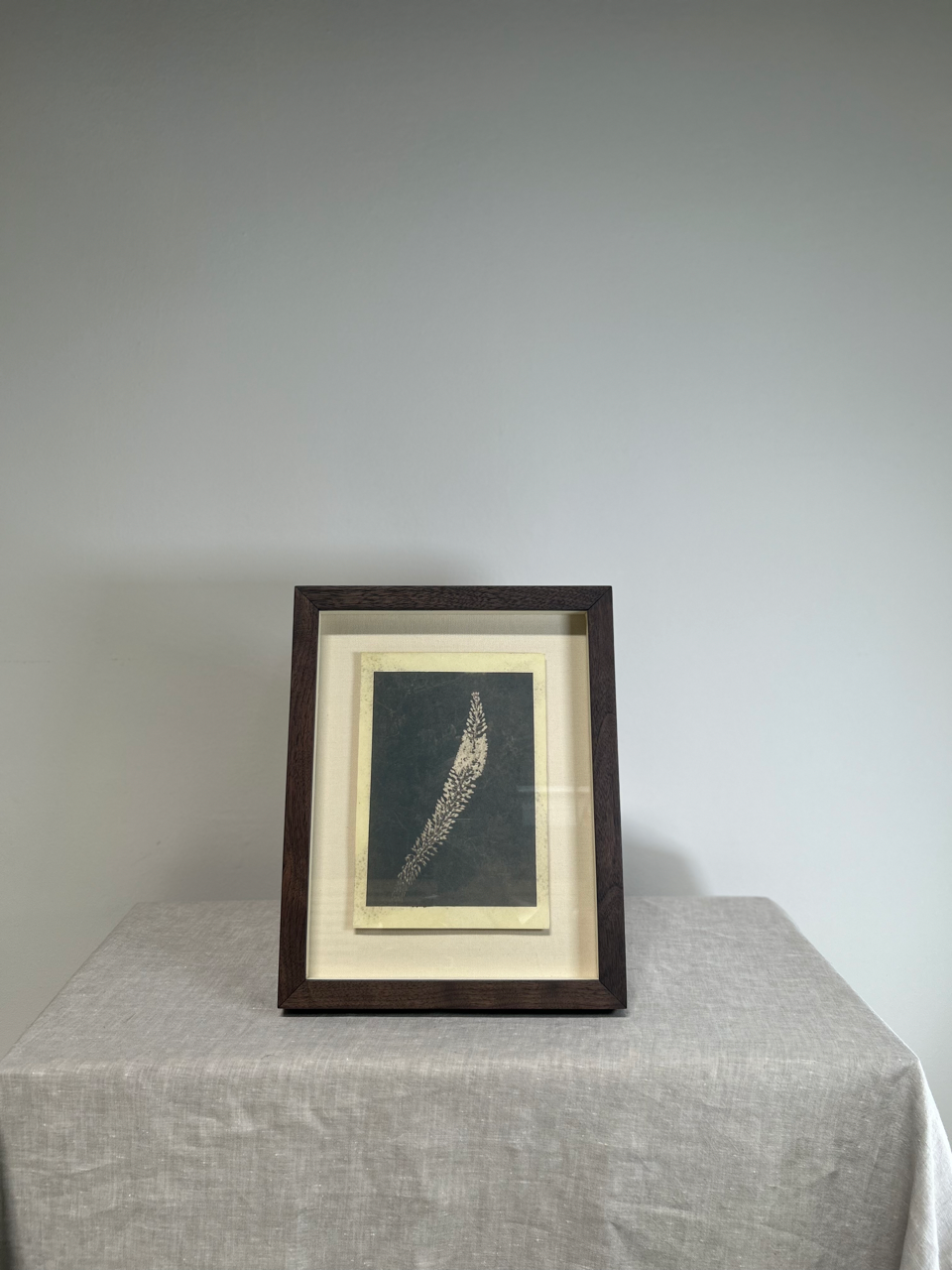 Framed artwork on a table with a plain background