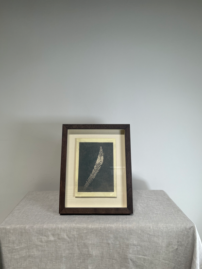 Framed artwork on a table with a plain background